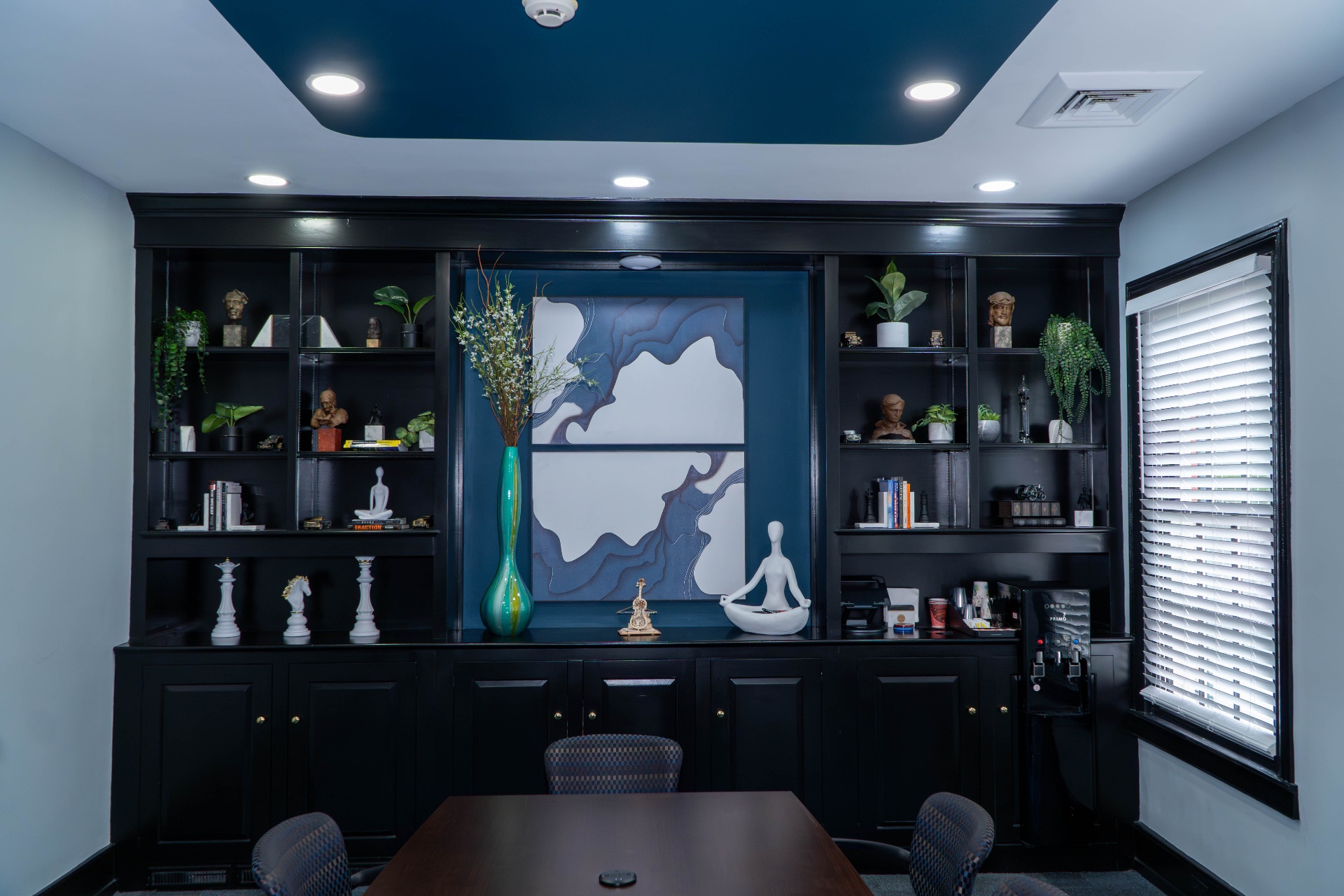 Built-in shelving with sculptural art and tray ceiling detail