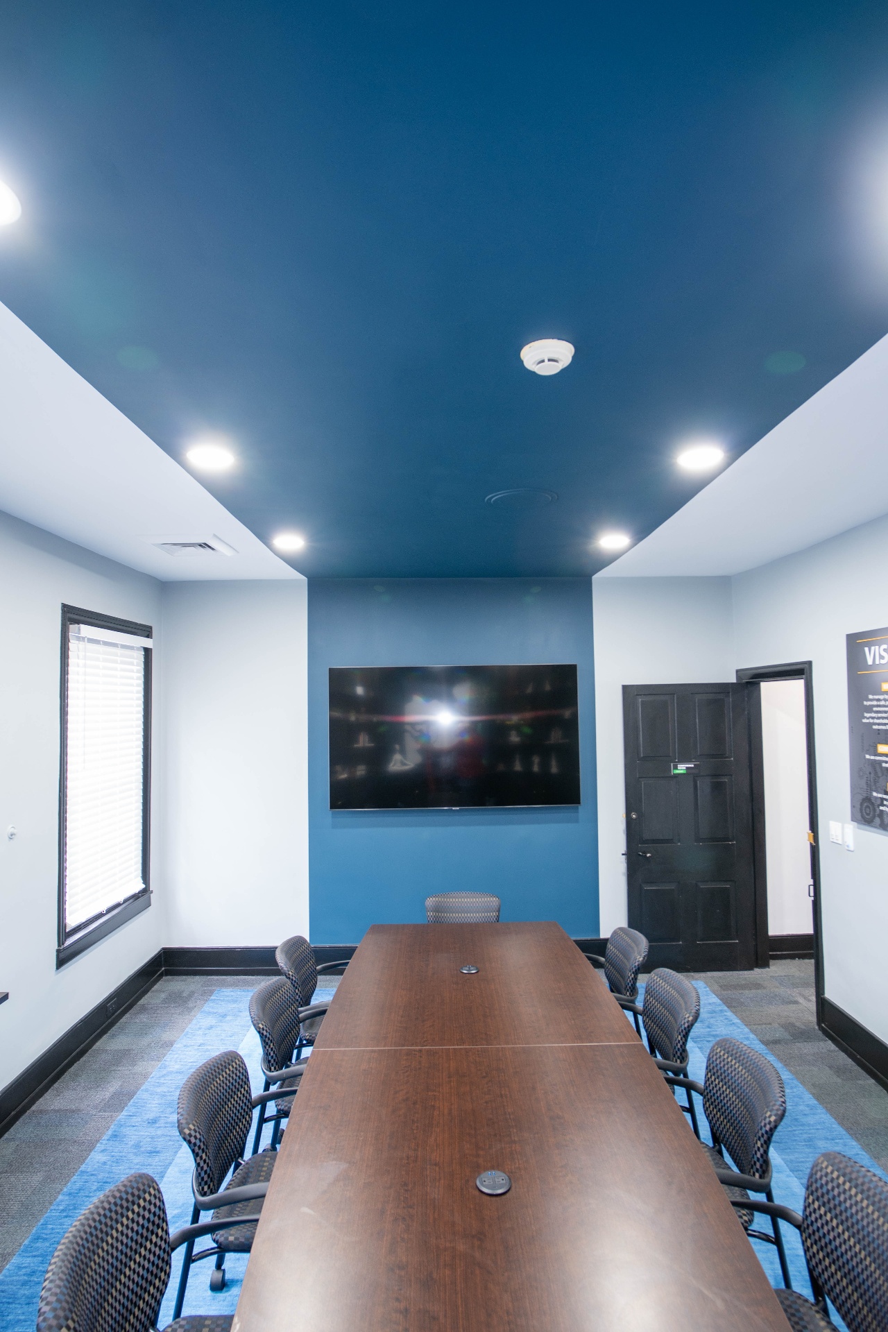 Second conference room with mounted display and teal accent wall