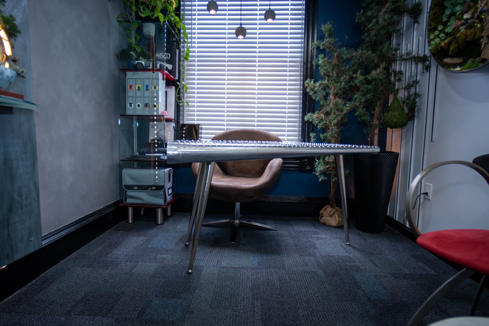 Aviator riveted desk centered on a moody blue accent wall