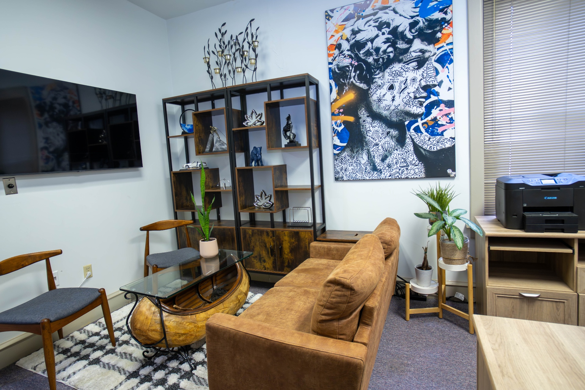 Wide lounge view with sofa, canoe coffee table, and pop-art canvas