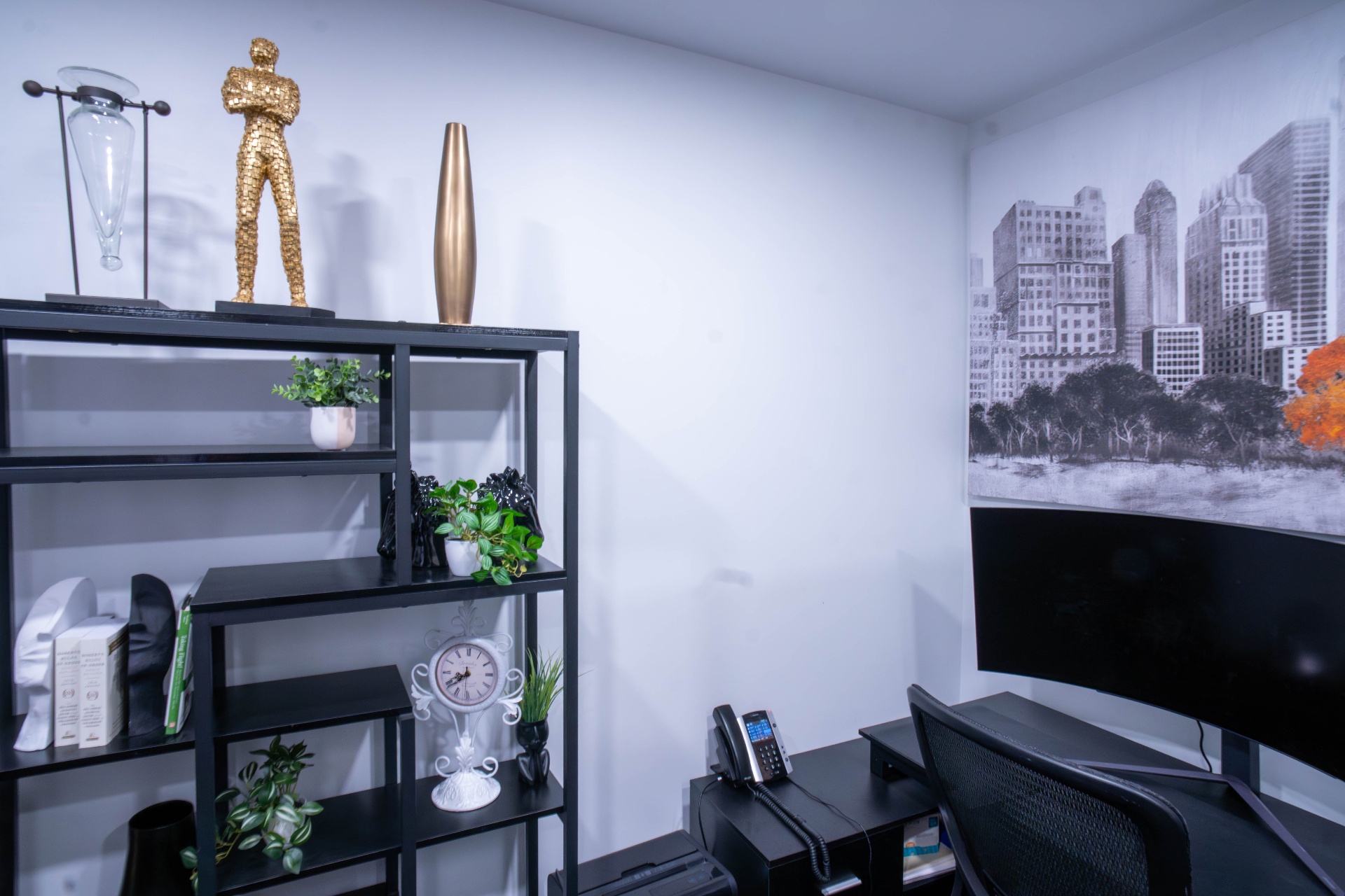 Workspace with sculptural gold figure and city skyline mural
