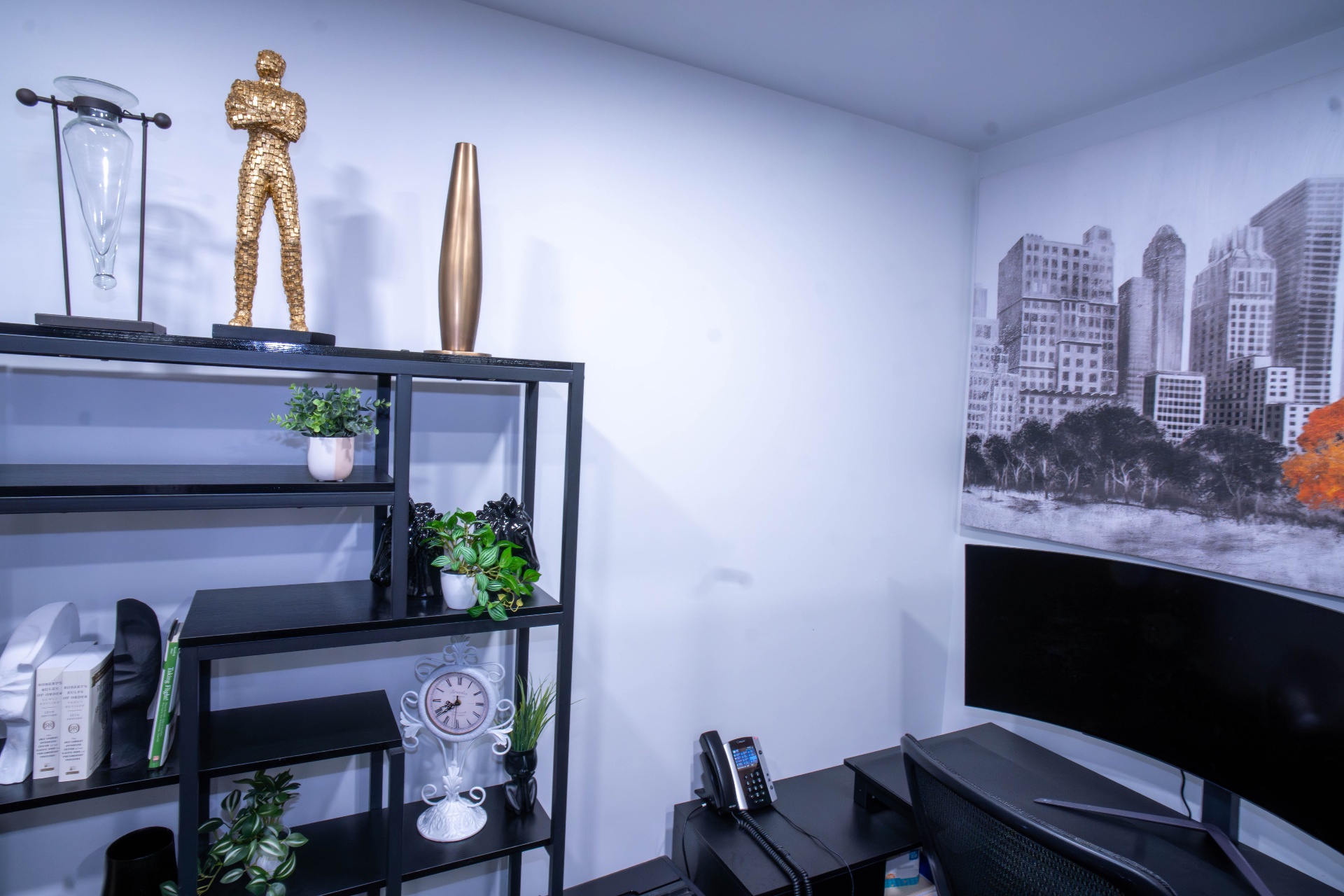Styled black shelving with gold sculpture against city mural backdrop