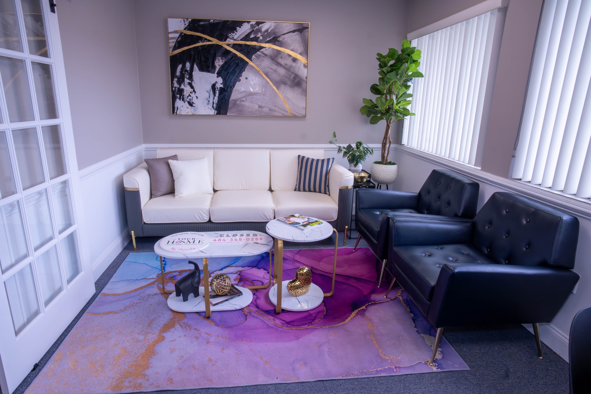 Reception lounge with cream sofa, navy chairs, and watercolor area rug