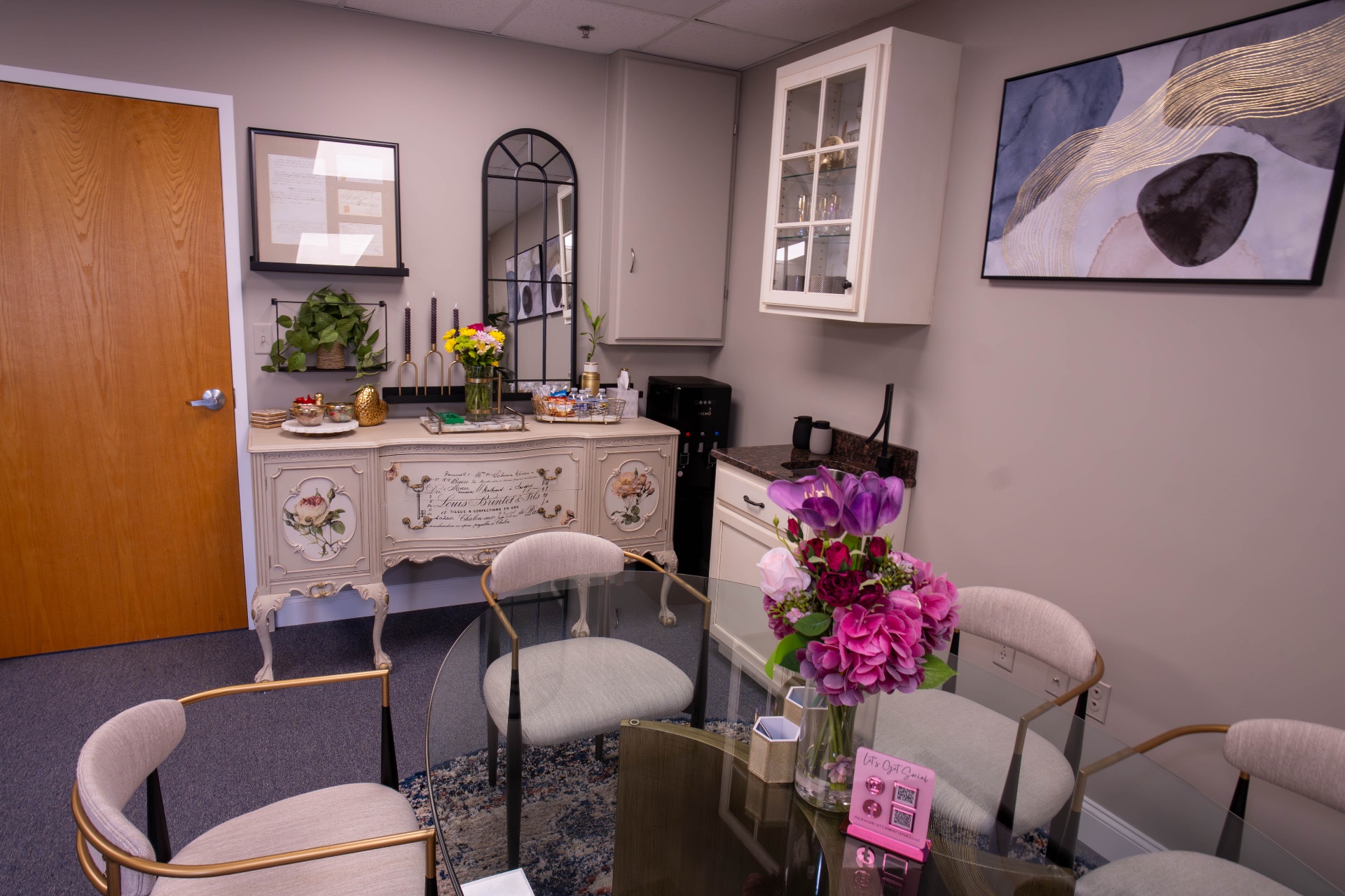Detail of meeting room with painted French sideboard and abstract art