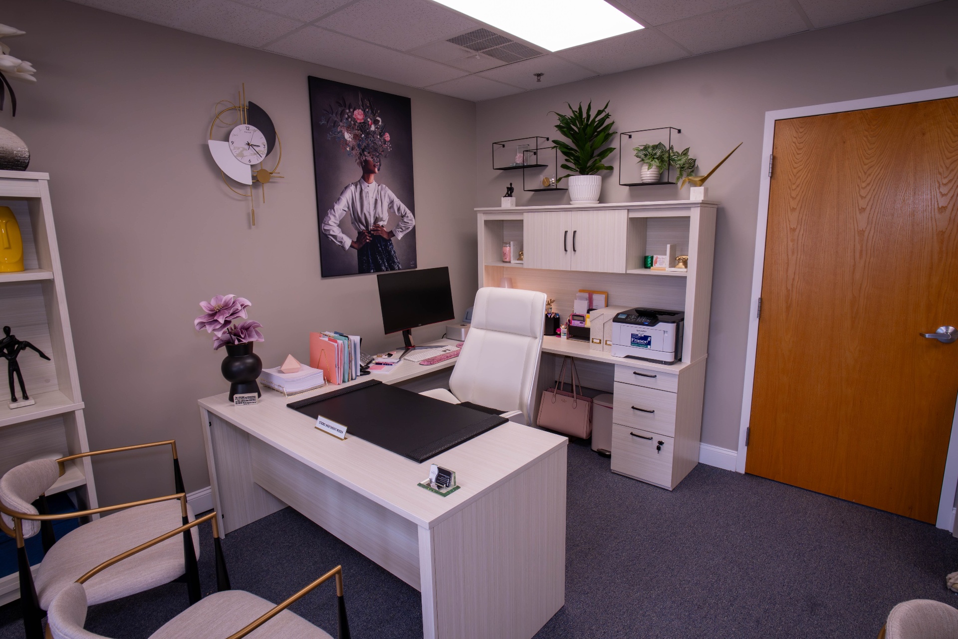 Founder's office in soft neutrals with gold accents and statement portrait