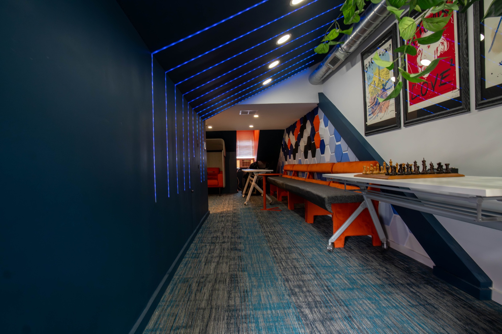 Collaborative lounge hallway with blue laser lighting and chess table