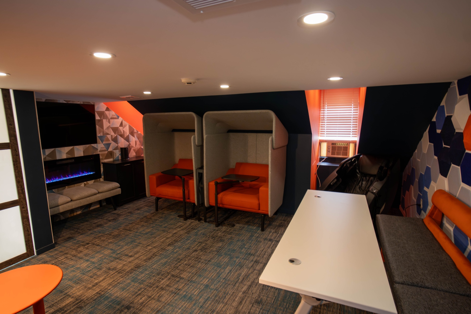 Breakout lounge with privacy pods, fireplace, and massage chair