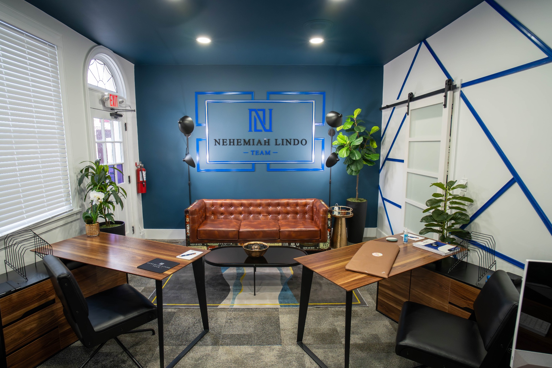 Symmetrical Nehemiah Lindo Team office with branded logo wall and twin desks