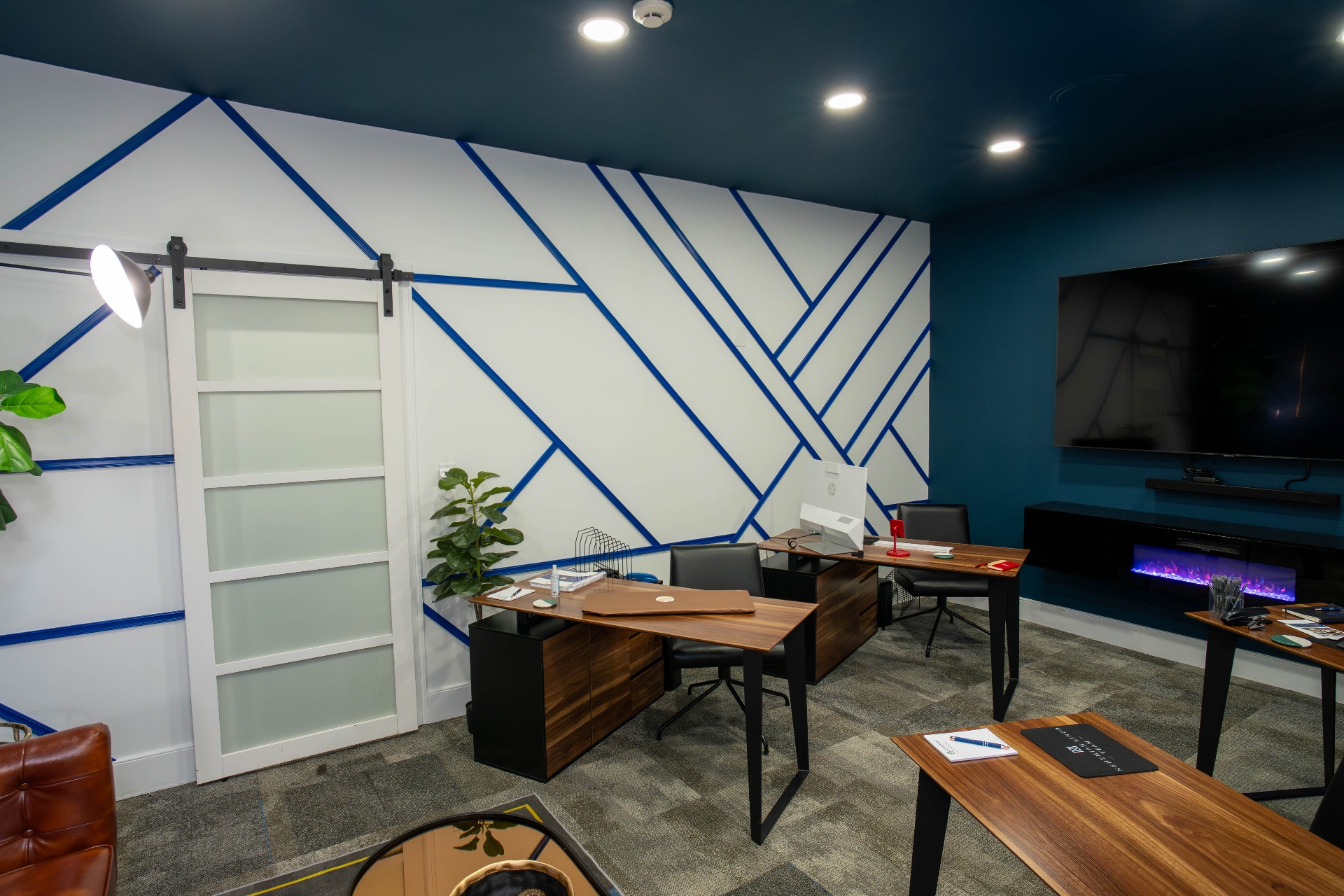 Nehemiah Lindo Team workspace with geometric blue striped feature wall and dual desks