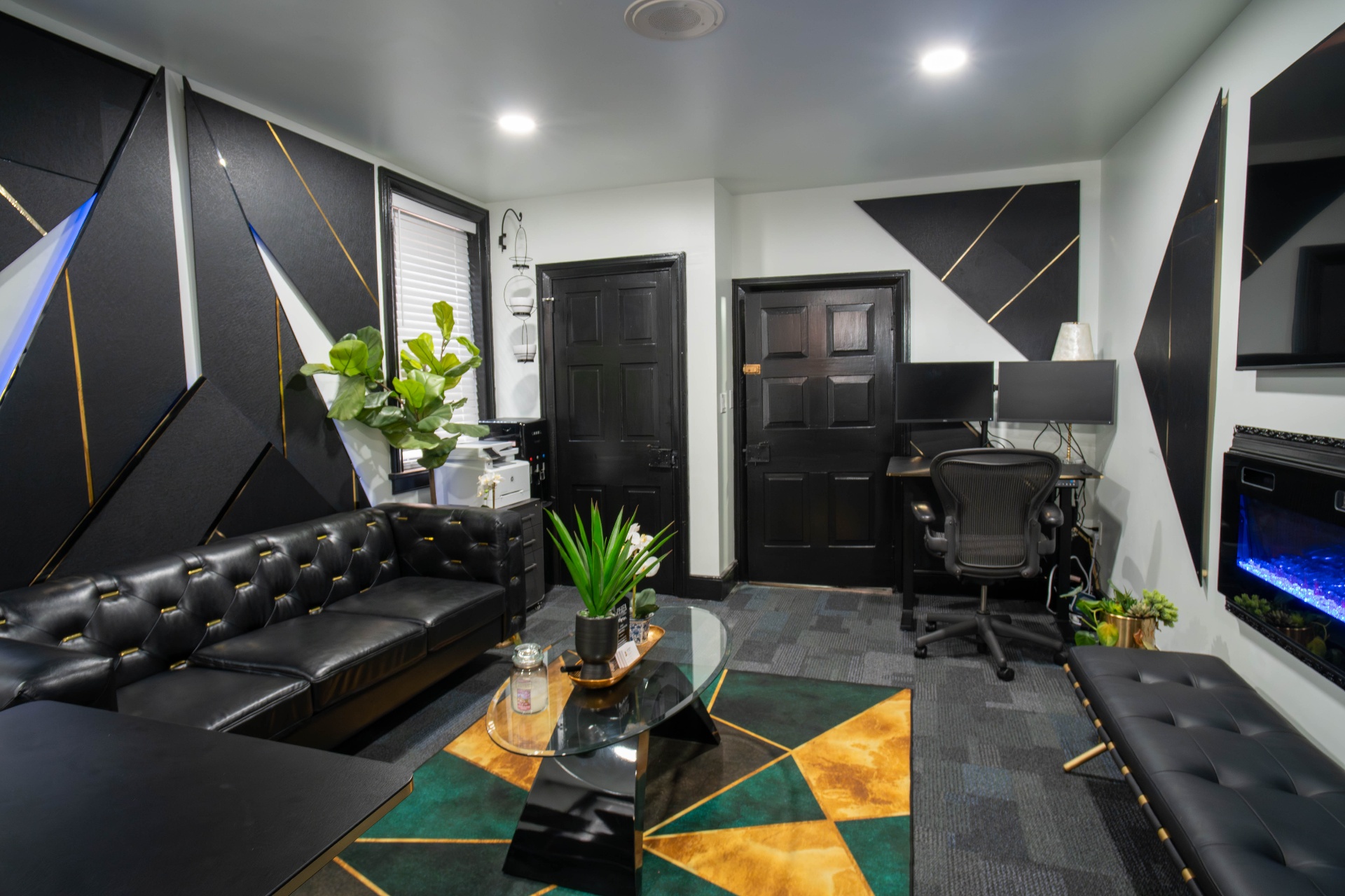 Wide view of executive office with chesterfield sofas, emerald geometric rug, and fireplace